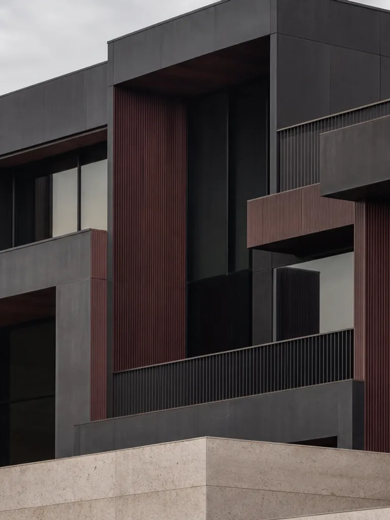 Interlocking dark architectural volumes with burgundy accents